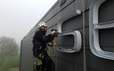 1 Abseiltechnieken monteren lichtreclame boven water rope access advertising (Middel)